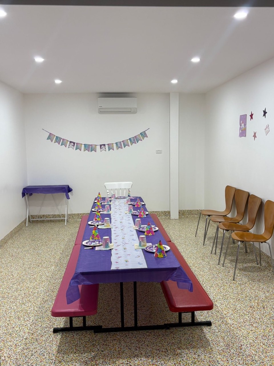Rumble Tumbles party room set up with purple tablecloth, party hats, and bench seating