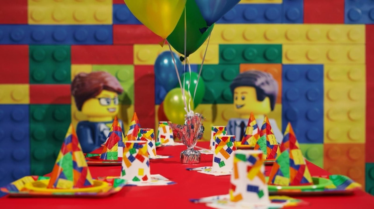 Lego-themed birthday party table with Lego brick backdrop and Lego figure cutouts