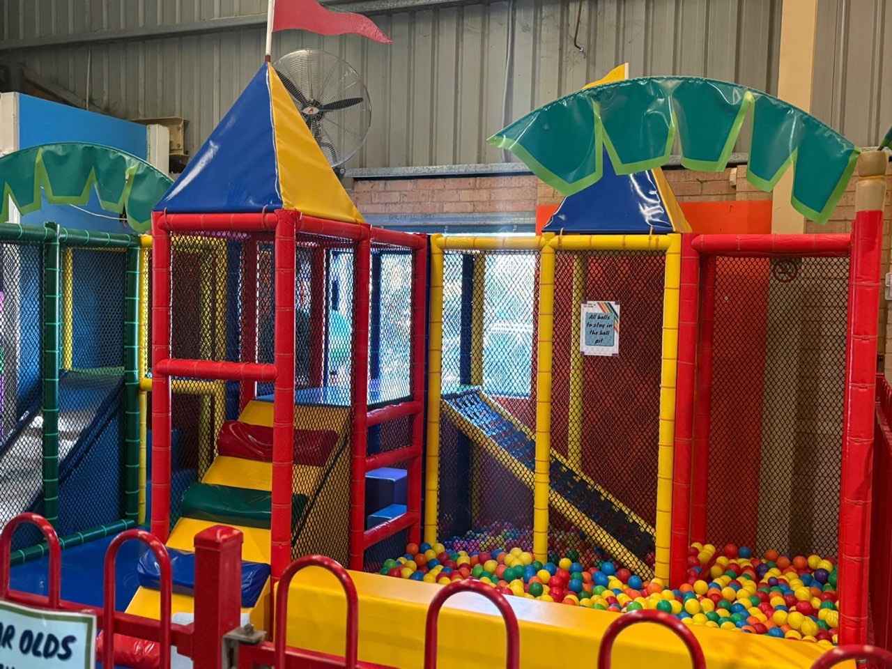 Soft padded toddler play structure with gated frame, slide, and small ball pit