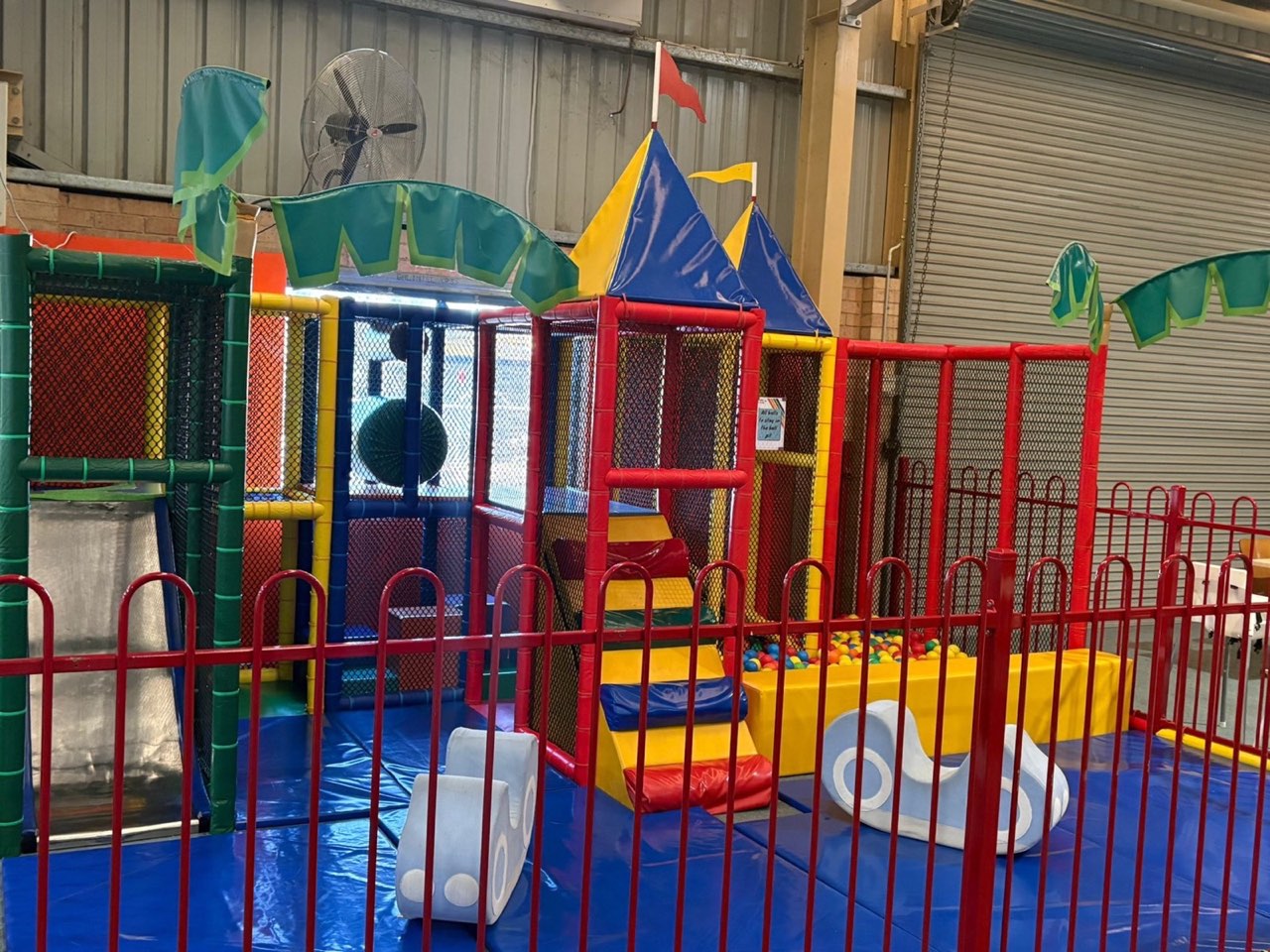 Side view of the toddler play area showing the green canopy and climbing frame